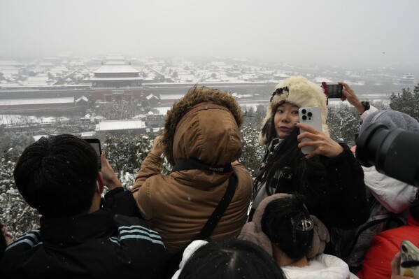 AP PHOTOS Crowds bundle up to take snowy photos of Beijing s